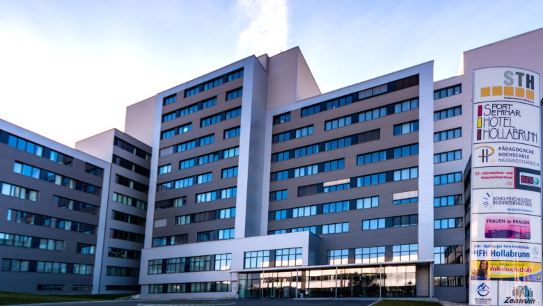 A modern multi-storey building with a sign that reads "Sport Seminar Hotel Hollabrunn".