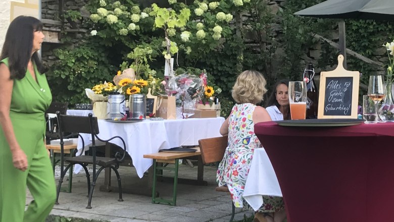 Garden party with decorated tables, flowers and drinks.