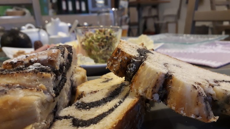 Close-up of poppy seed cake on a breakfast table with blurred background.