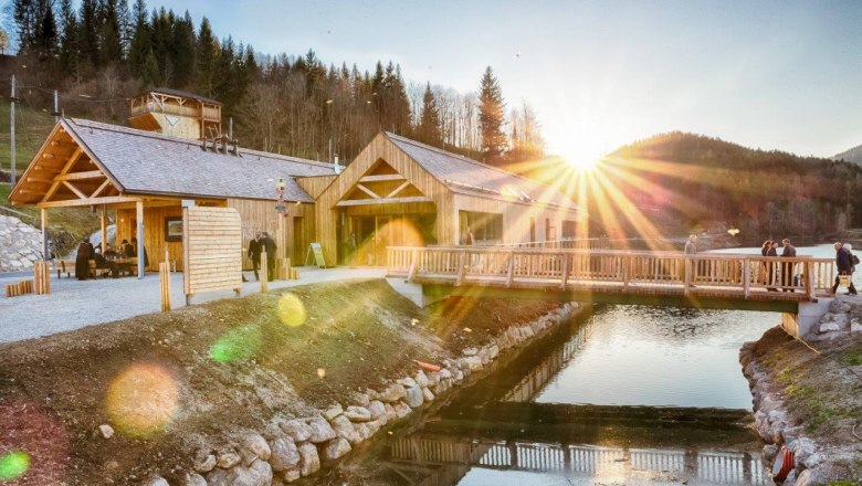 Ötscher base Wienerbruck with wooden buildings and bridge at sunset.