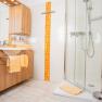 Modern bathroom with wooden furniture, shower and orange accents.