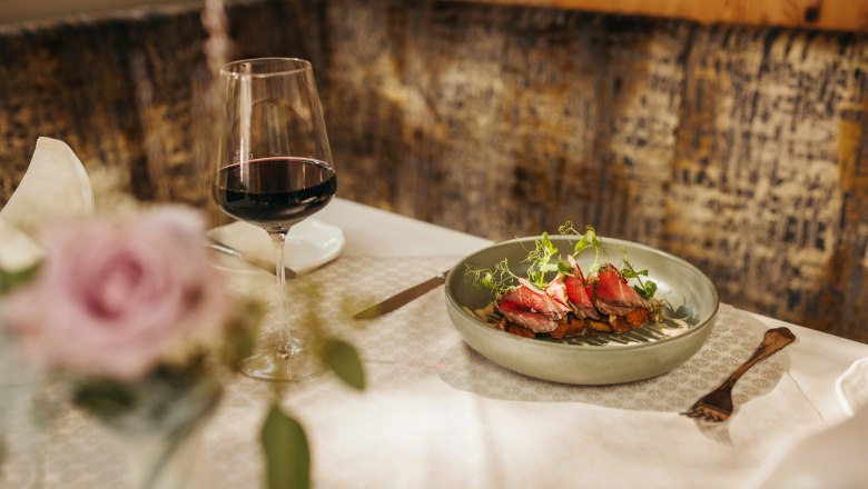 Elegant dish with red wine in a stylish restaurant ambience.
