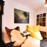 Cozy seating area with leather armchair, yellow beanbag, antique grandfather clock and murals.
