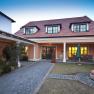 Guest house with red roof and garden in the foreground.