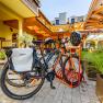 Bicycles on a bicycle stand in front of a hotel building.