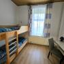 Small bedroom with bunk bed, desk and chair.