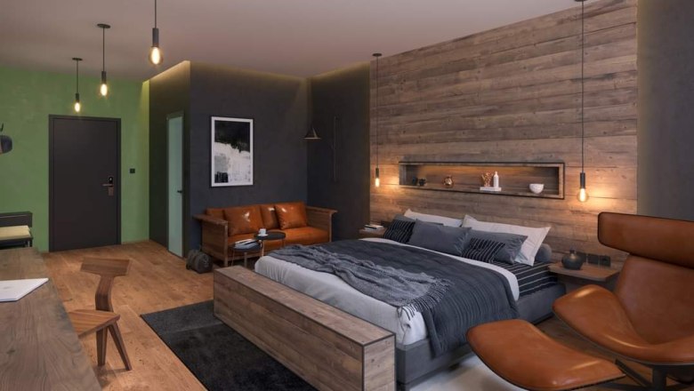 Modern bedroom with wooden wall, large bed, leather sofa and stylish lamps.
