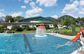 Puchberg outdoor pool with swimming pool, slide and green surroundings.