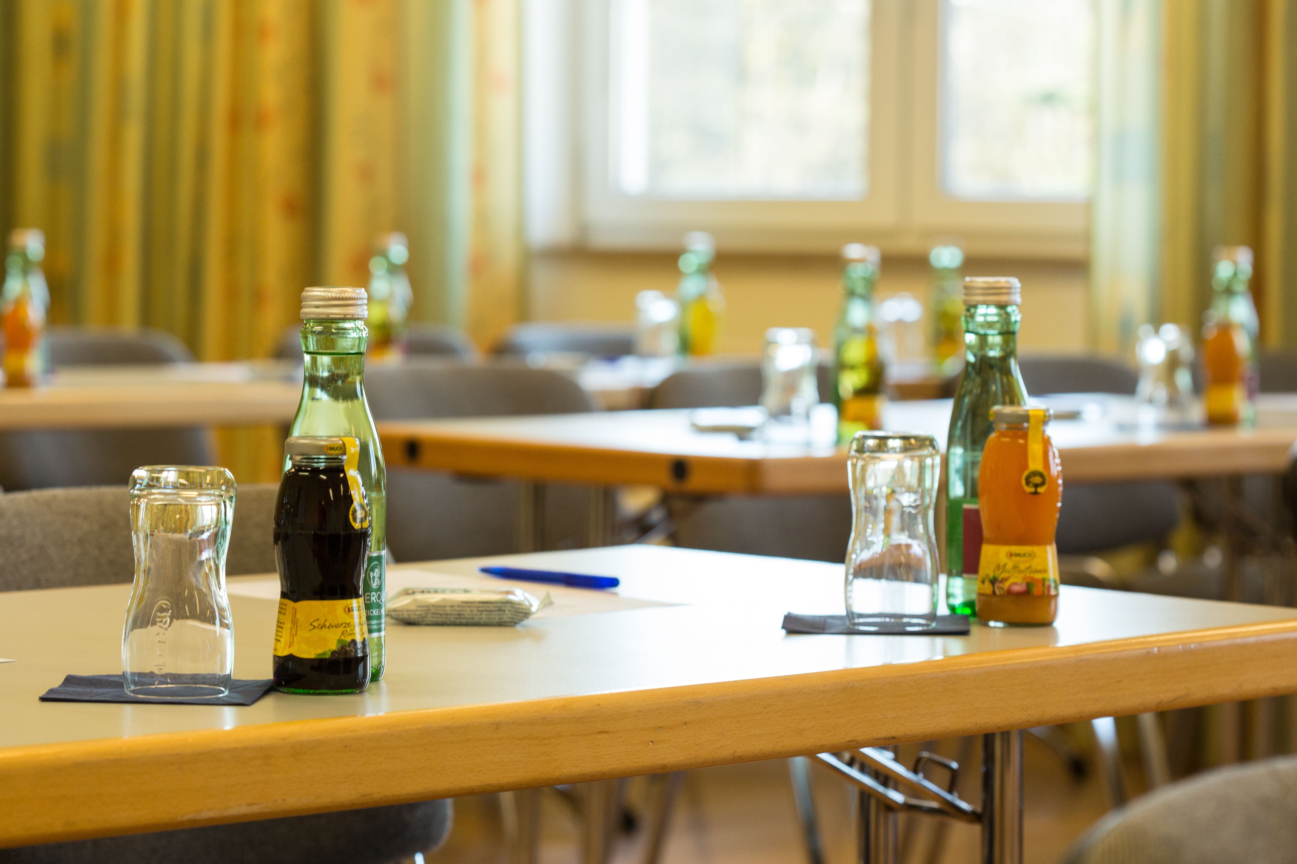 A seminar room with tables on which drinks and glasses are placed.
