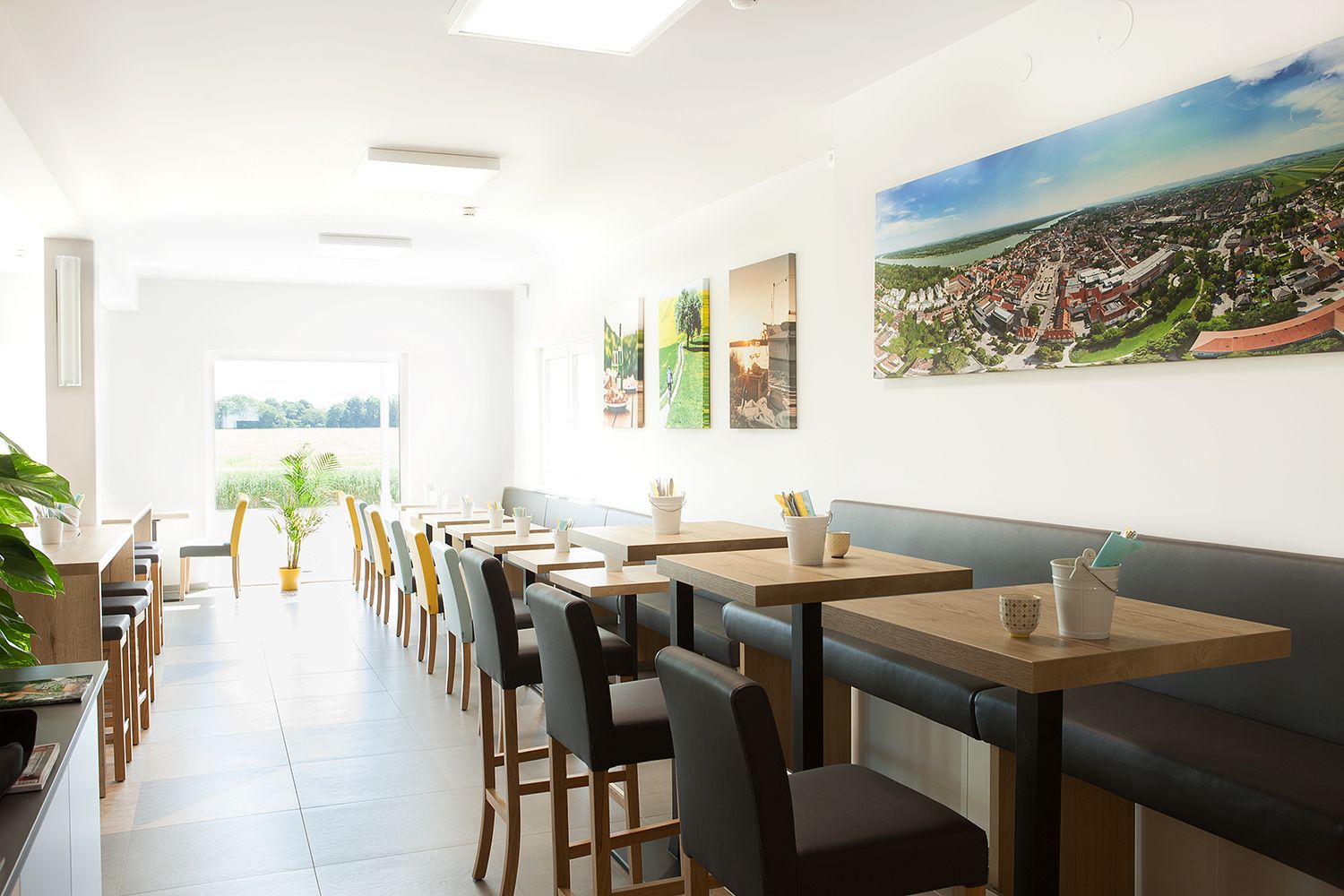 Breakfast room with gray upholstered seating and wooden tables.
