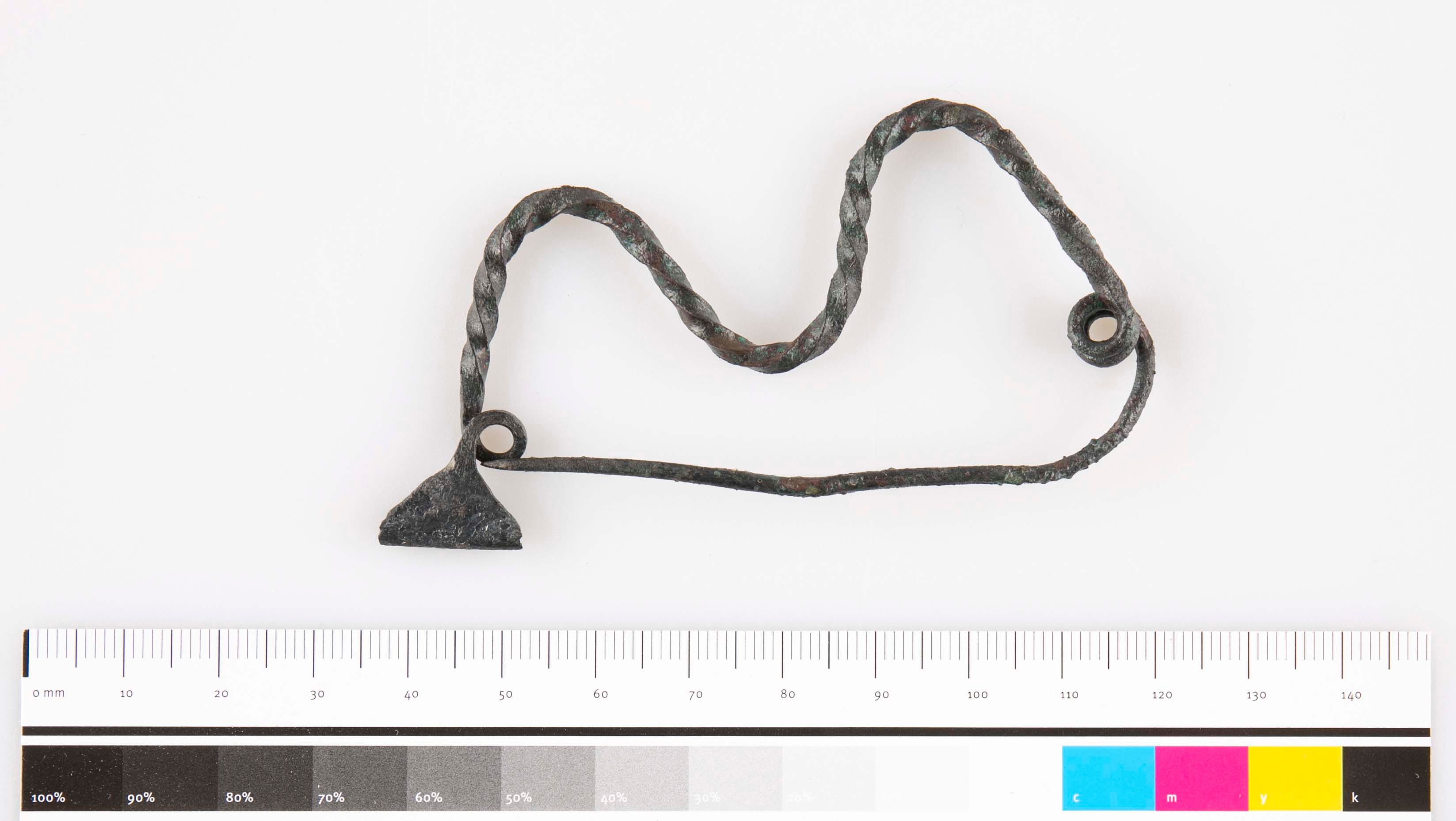 Metal object with twisted wire and scale.