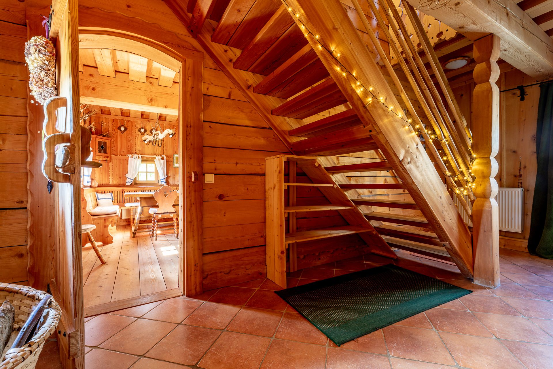 Wooden staircase in a house with wood paneling decorated with fairy lights.