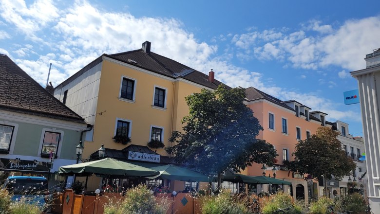 TDR-Adlerbräu outside, © Donau Niederösterreich Ketting Street scene with yellow building, café with parasols and bicycles in the foreground.