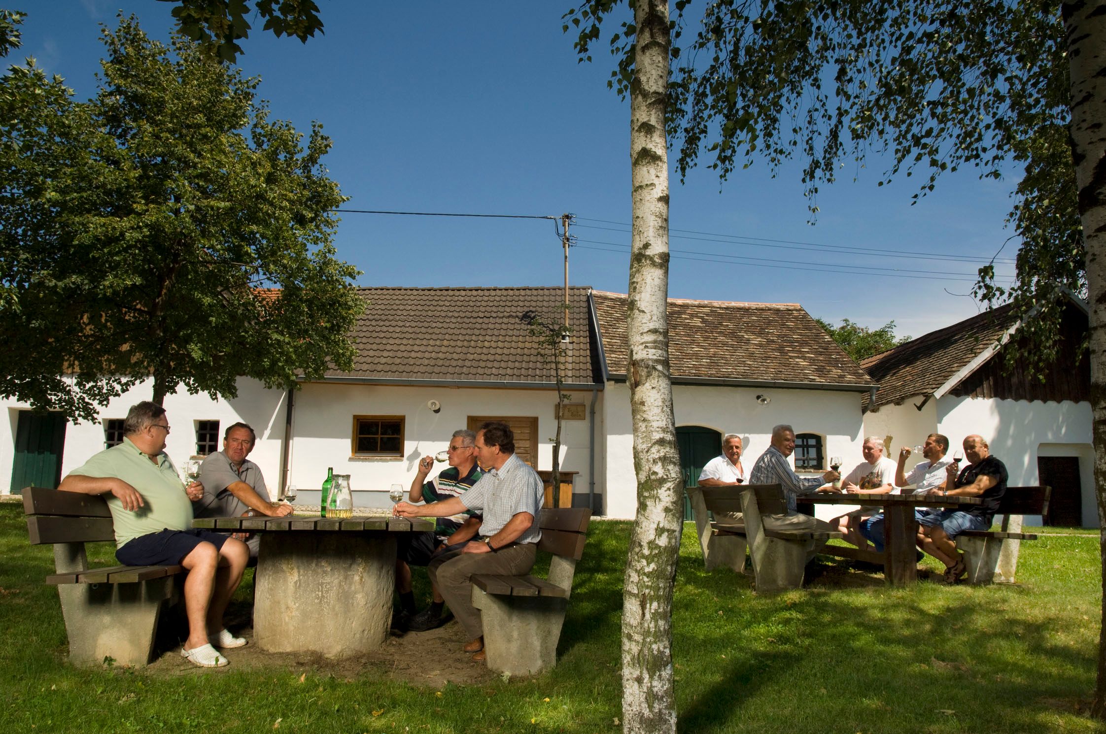People sit at outdoor tables in front of traditional buildings in Schöngrabern.