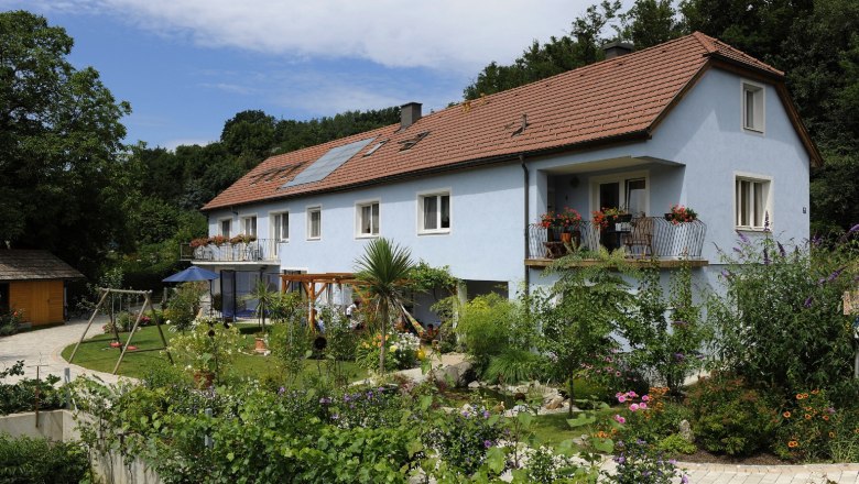 Exterior view of a blue guest house with garden and playground.
