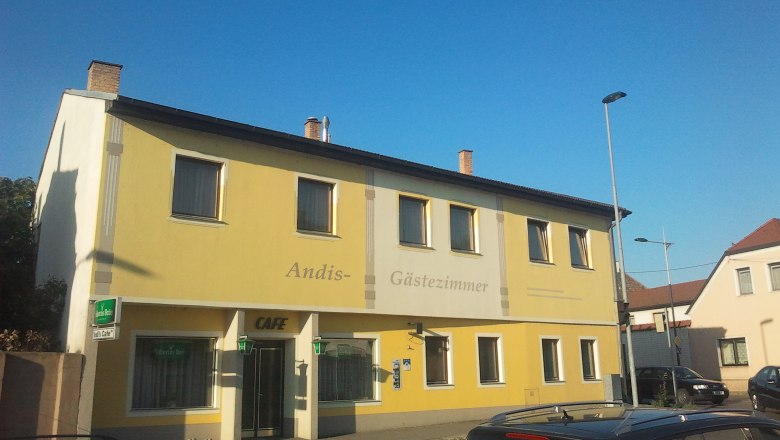 Yellow building with the inscription 'Andis G&auml;stezimmer' and 'Cafe'.