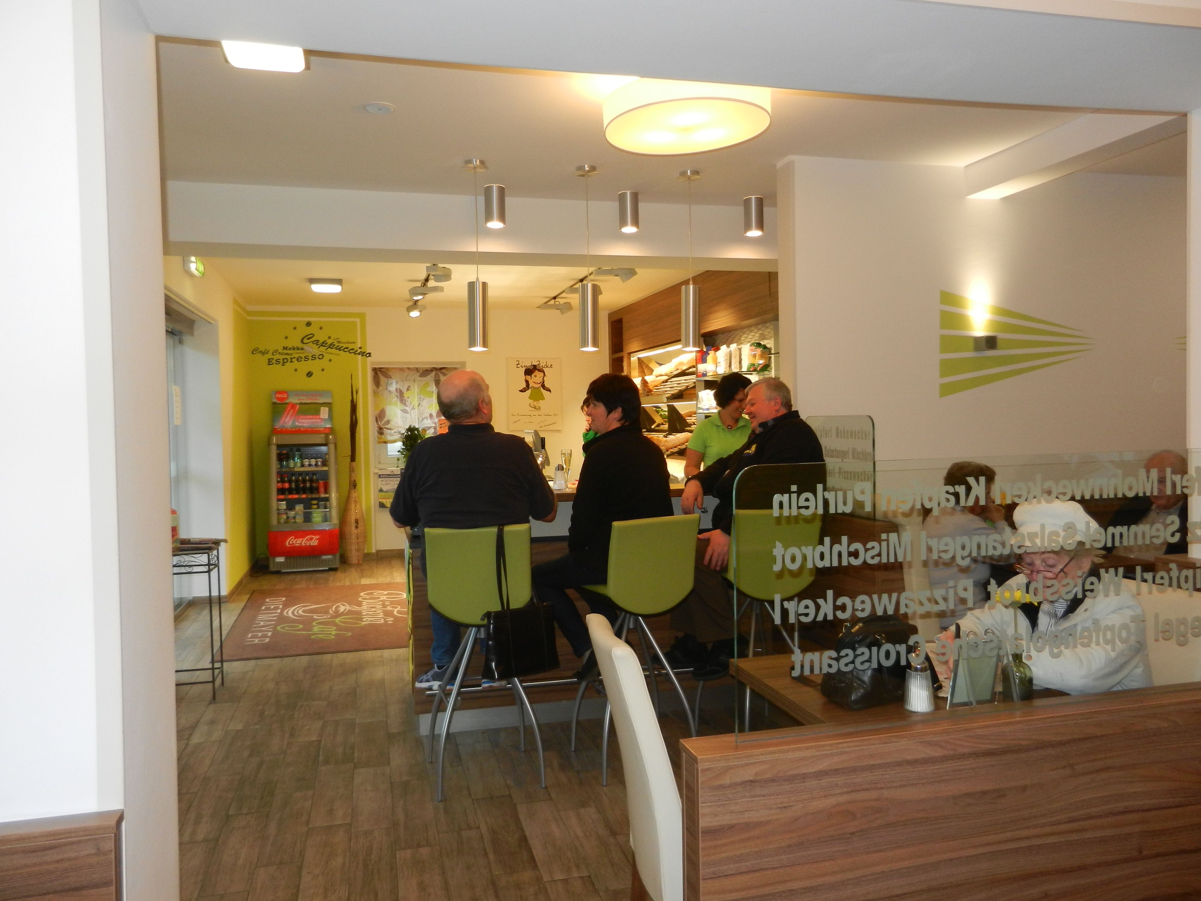 Interior view of a café with several people at a table.