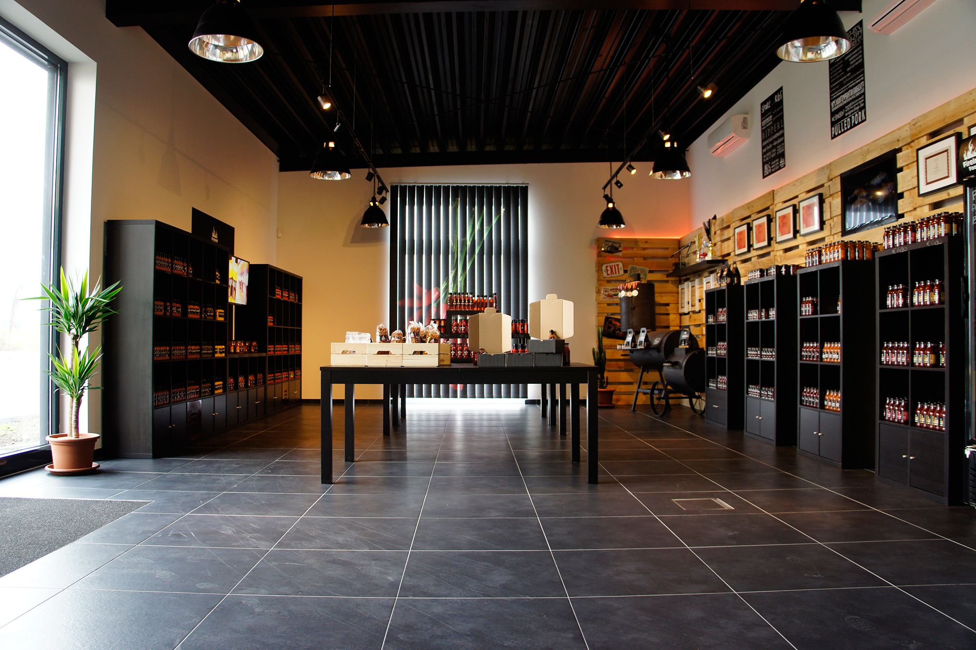 Interior view of a modern store with shelves full of products and a table in the middle.