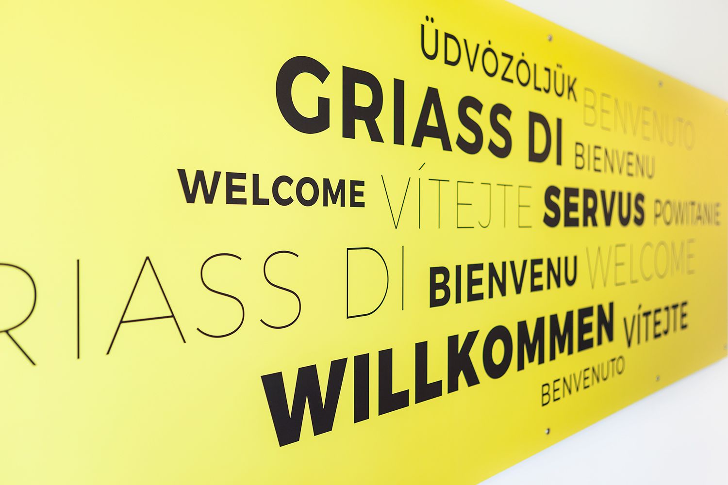 A sign with the word Welcome in various languages.