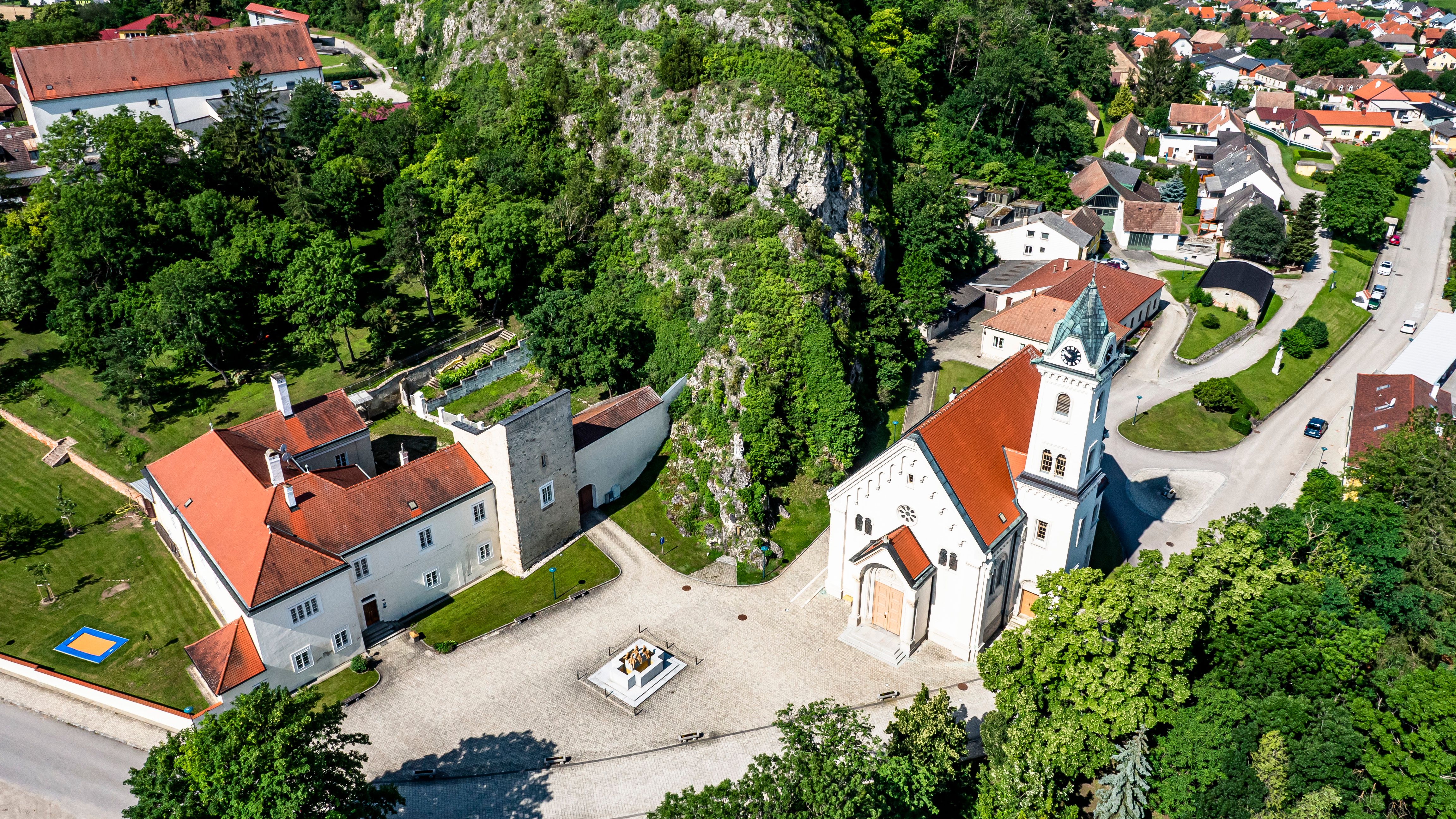 Aerial view of Staatz parish church with surrounding buildings and green spaces.