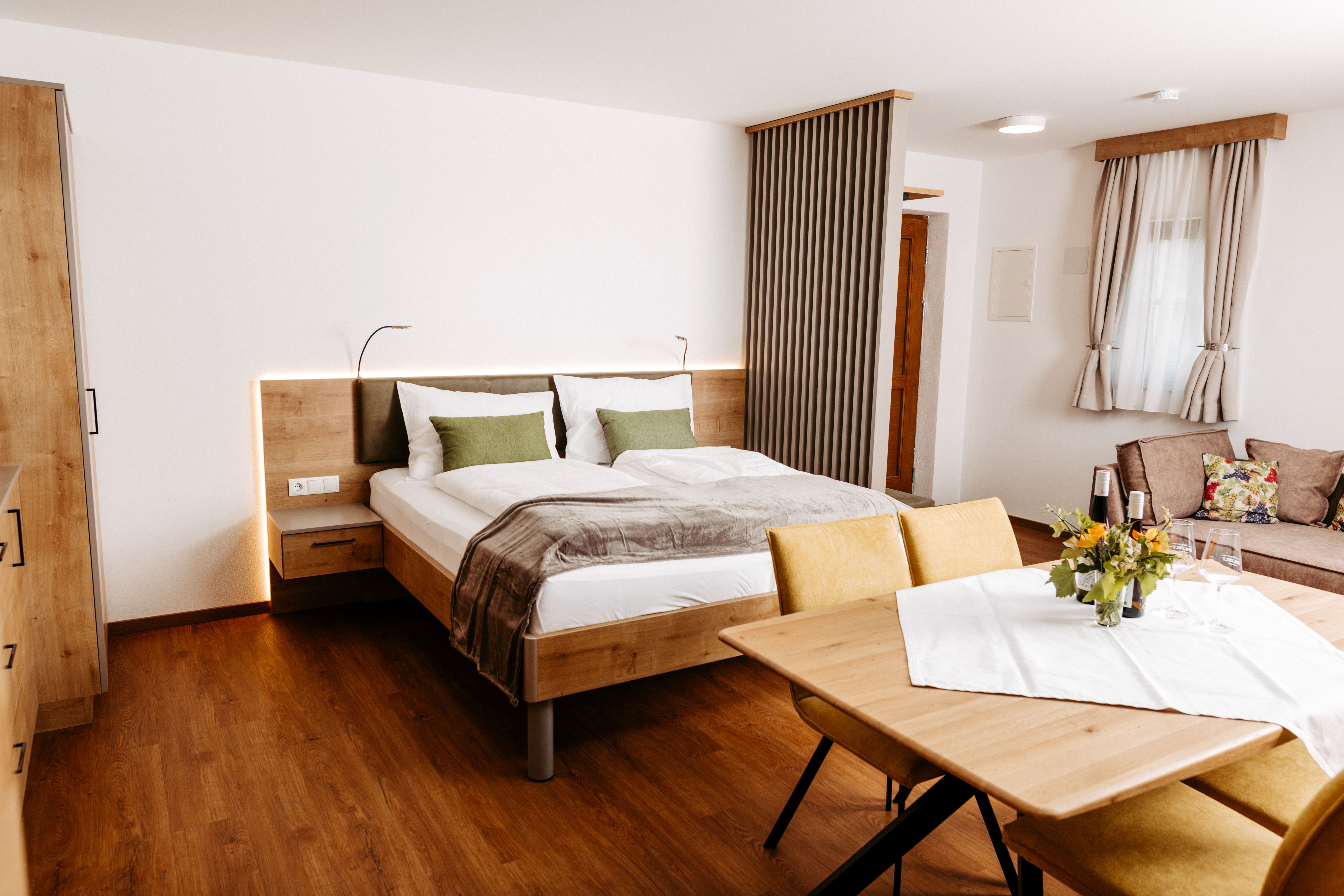 A modern, bright double room with a sitting area and wooden furniture in a stylish accommodation on the Wagram.