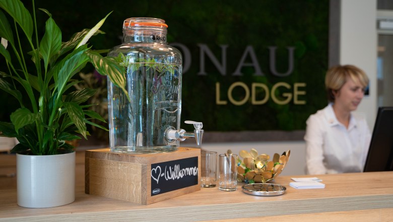 Reception with water dispenser, plants and staff at the computer.