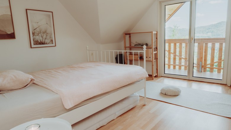Bright bedroom with bed, balcony and minimalist furnishings.