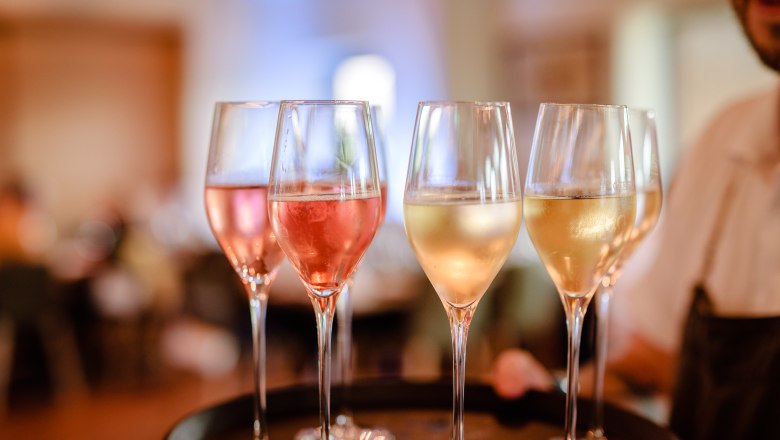 Close-up of champagne glasses on a tray, filled with ros&eacute; and white sparkling wine.