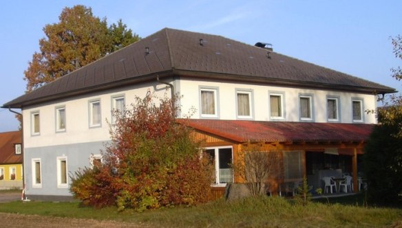Stefanie rest stop, © Bernhard Berger Two-storey building with a gray roof and white walls, surrounded by trees and shrubs.