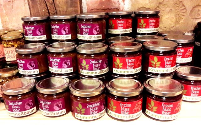 Jars of jam and nut spreads on a shelf.