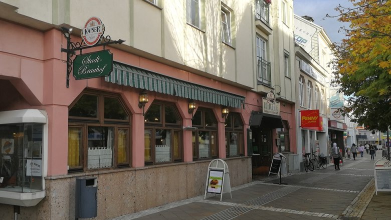 Street scene with the Stadtbrauhof Amstetten and surrounding stores.