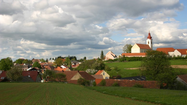Landscape with village and church under a cloudy sky.