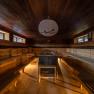 Interior view of a sauna with wooden benches and central stove.