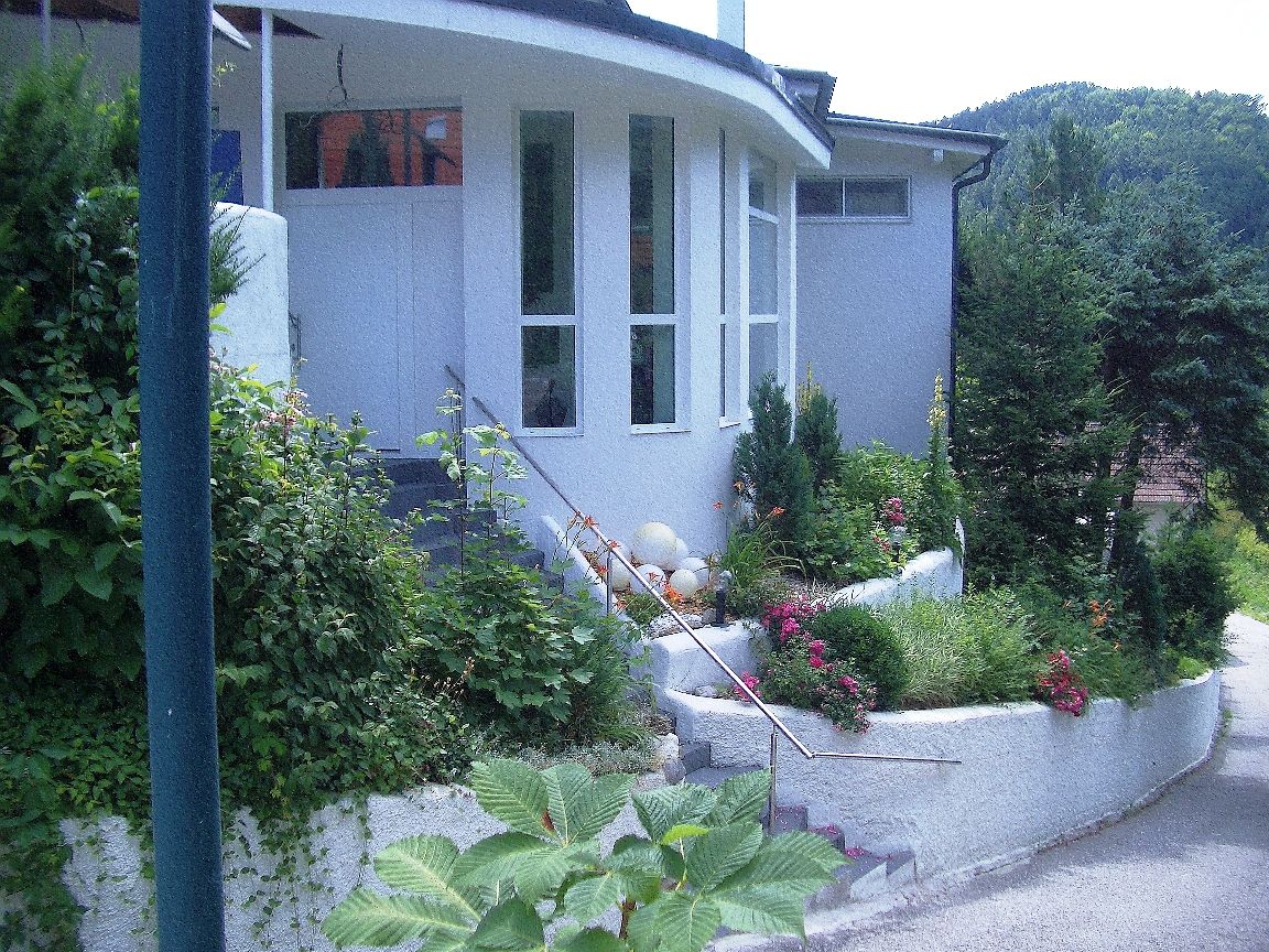 Entrance of a modern building with garden and staircase.
