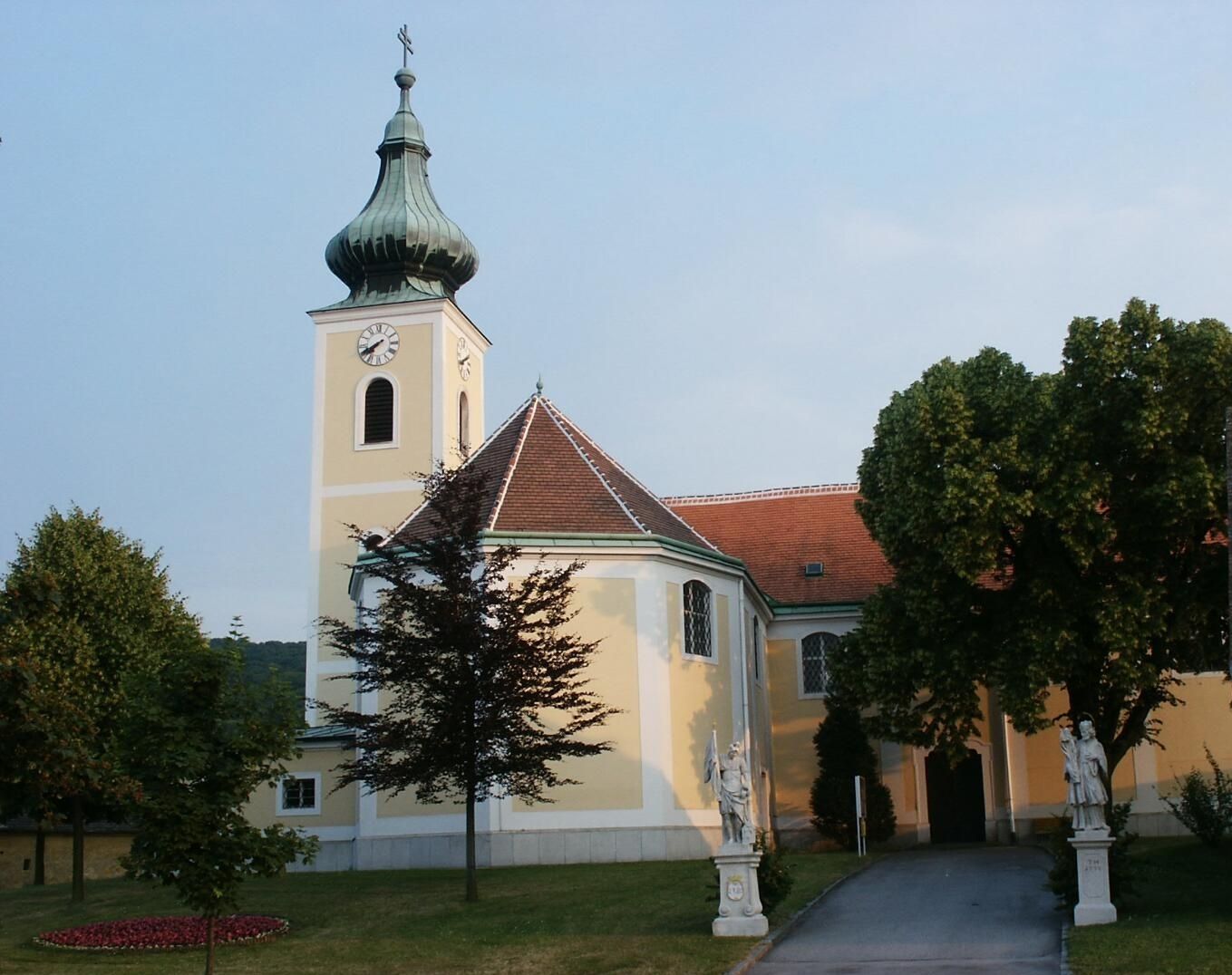 Wolfsthal pilgrimage church with tower and statues in the foreground.