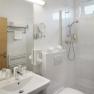 Modern hotel bathroom with shower, washbasin and toilet.