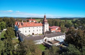 Aerial view of Dobersberg Castle with red roof and surrounding landscape.