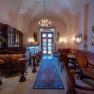Elegant interior of a hotel bar with wooden furniture, chandelier and carpet.