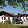 A country inn with white walls and a brown roof, surrounded by trees and cars in a parking lot.