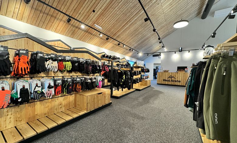 Interior view of a sports store with wooden shelves and sportswear.