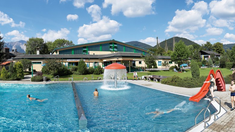 Puchberg outdoor pool with swimming pool, slide and green surroundings.