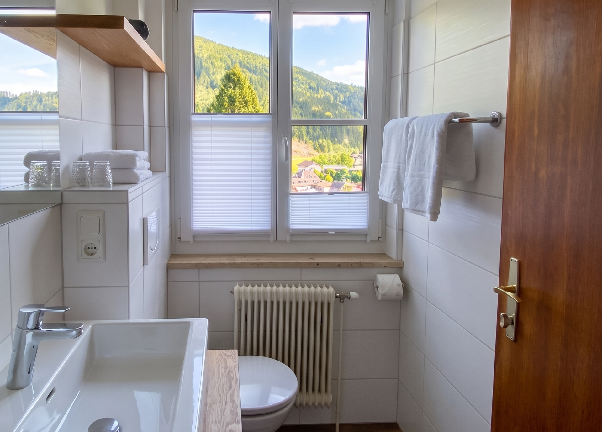 A modern bathroom with a window overlooking a green landscape.