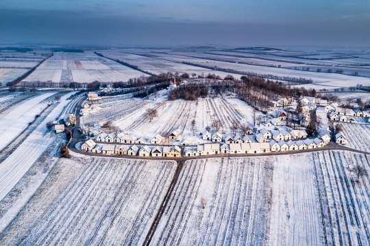 Colourful wine cellar-lined roads framed in white, © Robert Herbst