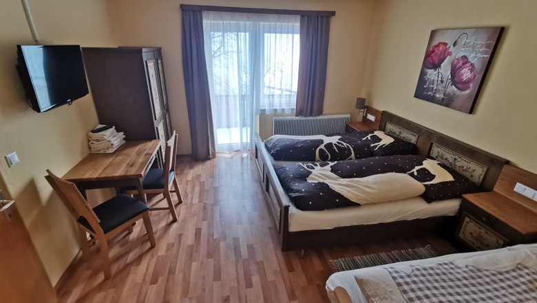 Comfortable bedroom with double bed, table, chairs and balcony access.