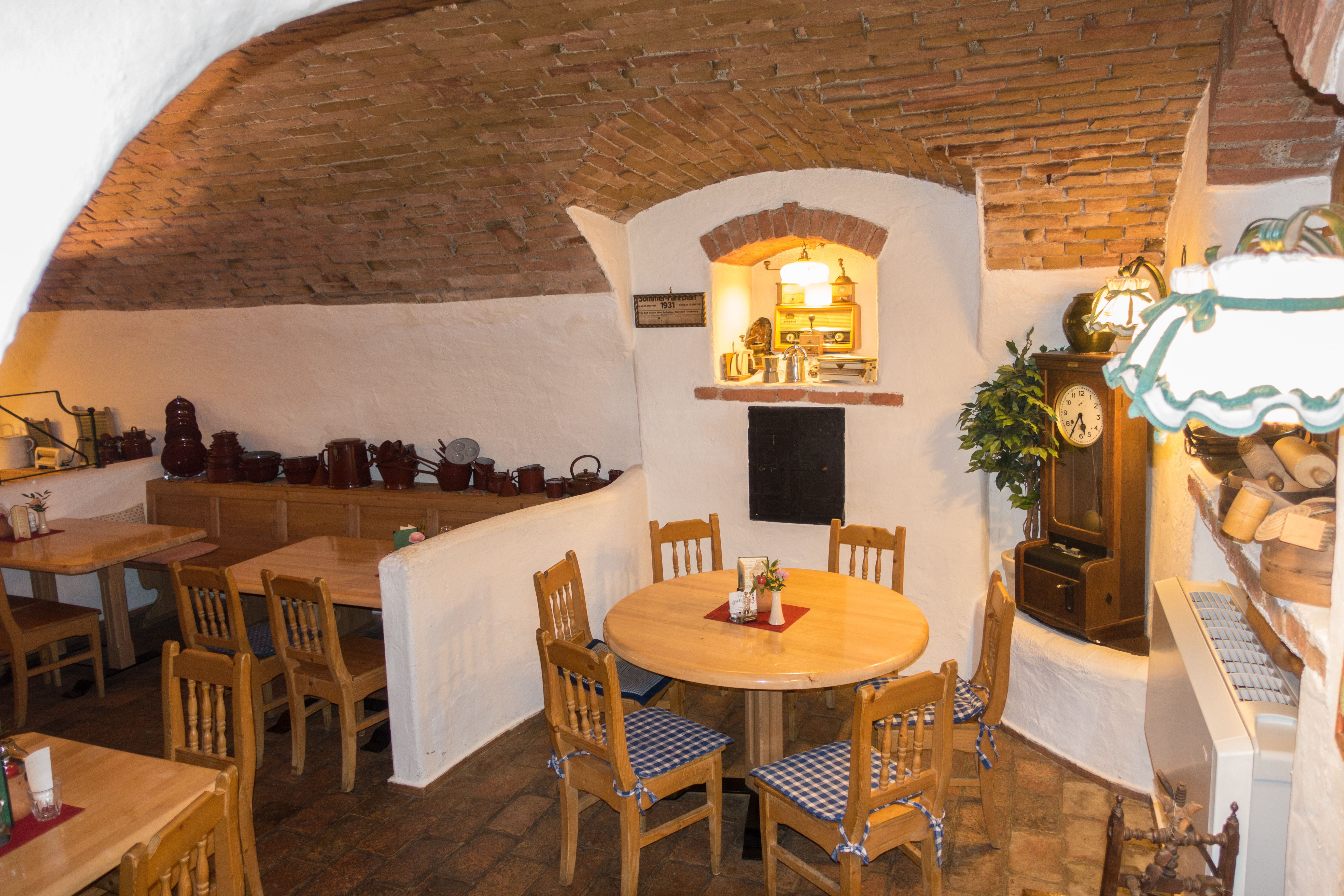 Cozy dining room with wooden tables and chairs, brick vaults and rustic decoration.