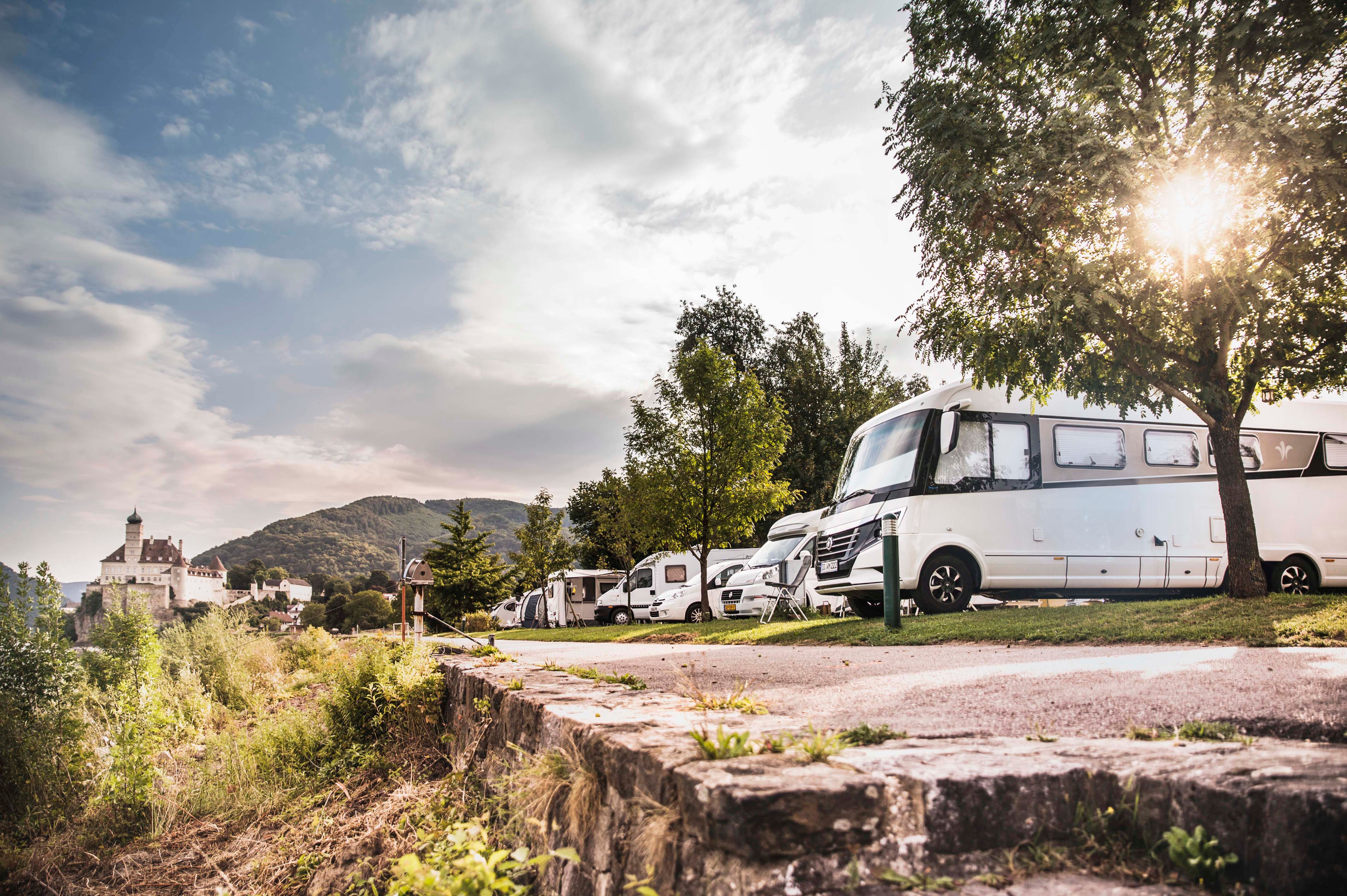 Motorhomes on a campsite with Schönbühel Castle in the background.