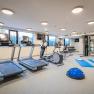 Fitness room with treadmills, cross trainers, dumbbells and exercise mats.