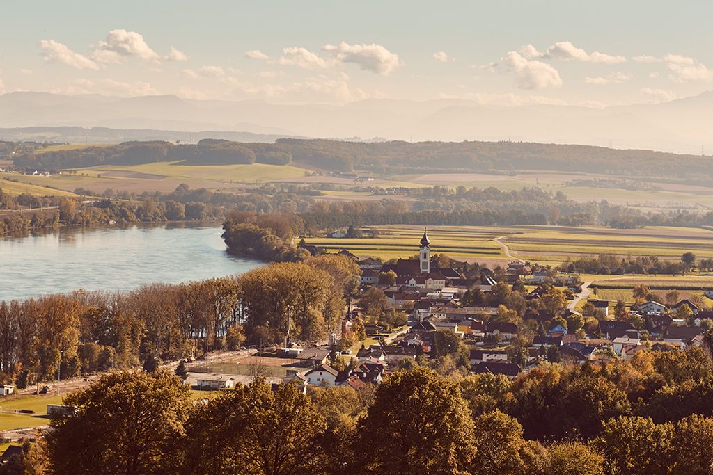 Landscape view of Gottsdorf in the Nibelungengau with river and church.
