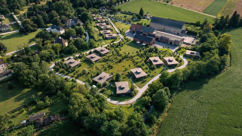Grafenegg Cottages, © Niederösterreich Werbung / Maximilian Pawlikowsky Aerial view of Grafenegg Cottages surrounded by green countryside and fields.