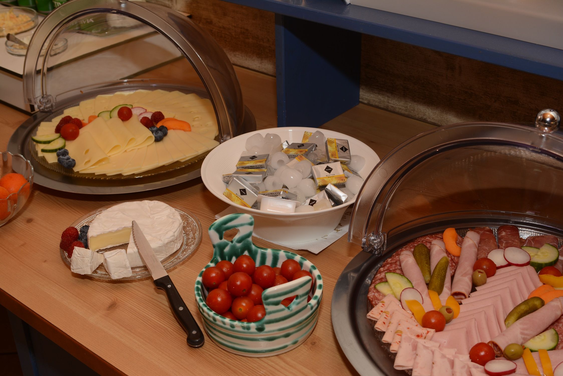 Breakfast buffet with cheese, sausage, tomatoes, butter and Camembert.
